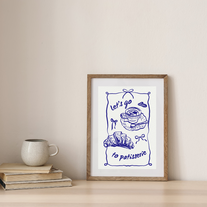 Framed artwork with 'Let's go to patisserie' text and illustrations on a wall above books and a mug.