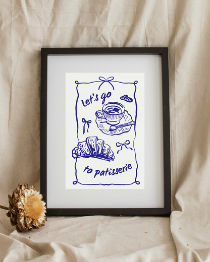 Framed artwork with blue line drawing and text 'Let's go to patisserie' on a beige fabric background.