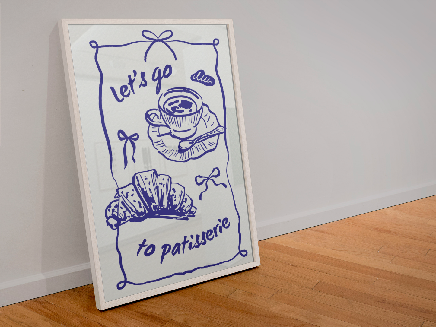 Framed artwork with blue line drawing of a teacup, croissant, and text 'Let's go to patisserie' on a white background.